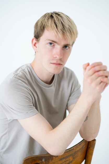 Photo portrait of young man sitting against white background