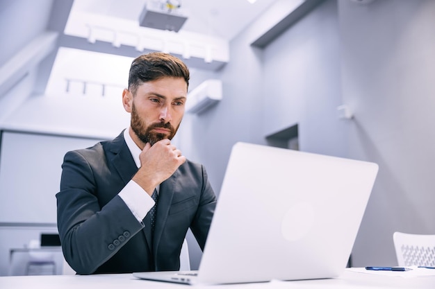 Portrait of a young man sitting at his desk in the office workin