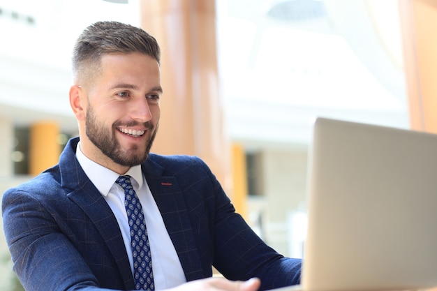 Portrait of young man sitting at his desk in the office.