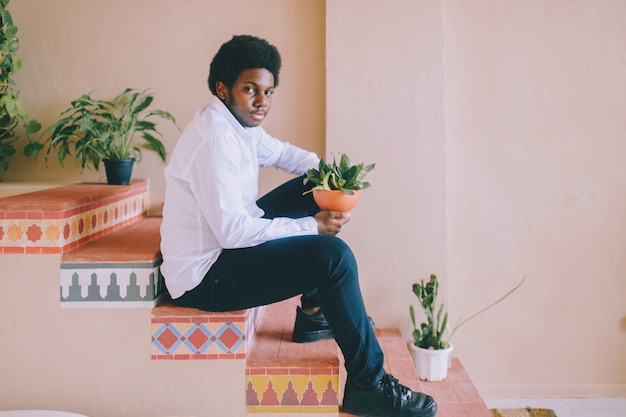 Portrait of young man sitting on stairs with patterns