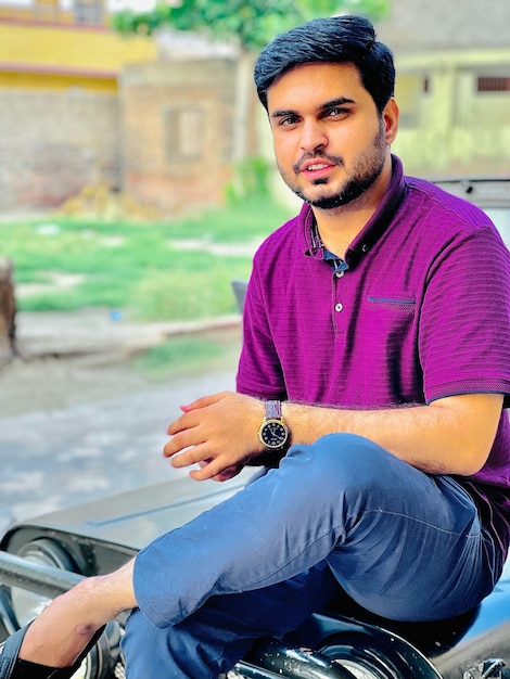 Portrait of young man sitting on street