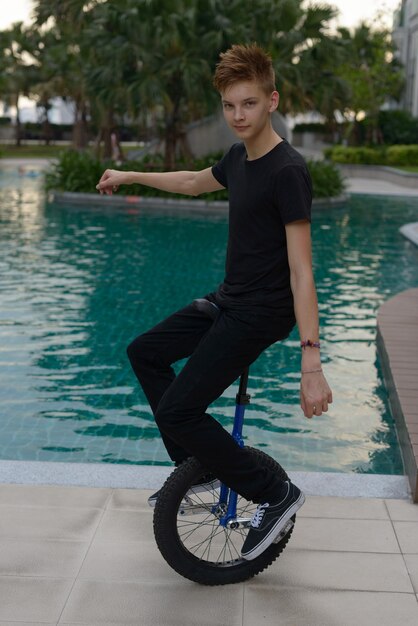 Photo portrait of young man sitting in swimming pool