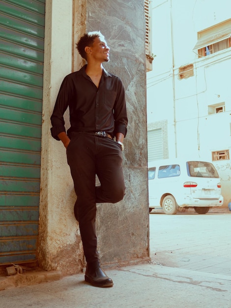 Portrait of young man sitting on wooden wall with the effect of a vintage old film camera