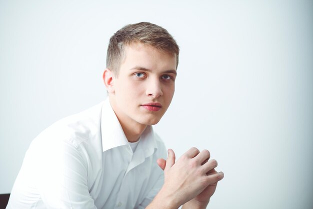 Portrait of young man smiling sitting on gray background Portrait of young man