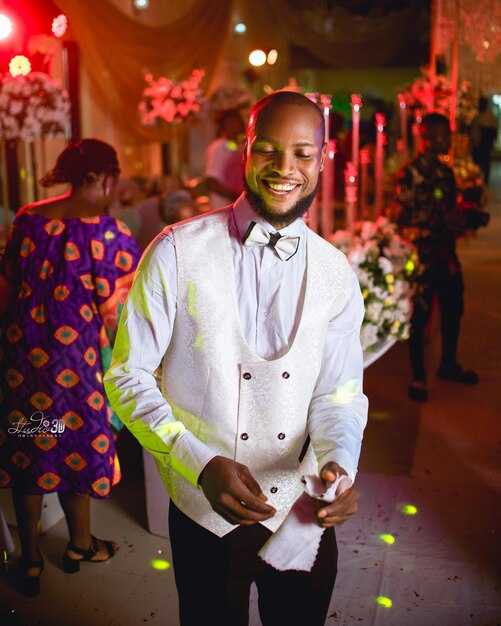 Photo portrait of young man smiling and standing in an event hall