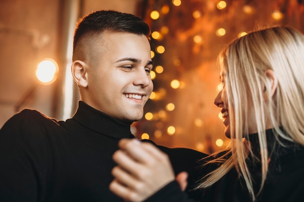 Portrait of a young man smiling while looking at his girlfriend.