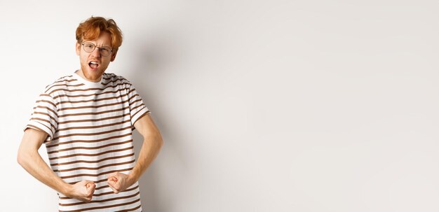 Portrait of young man standing against black background