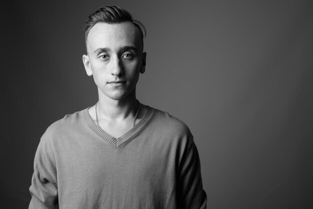 Photo portrait of young man standing against black background