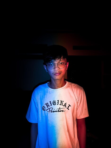 Photo portrait of young man standing against black background