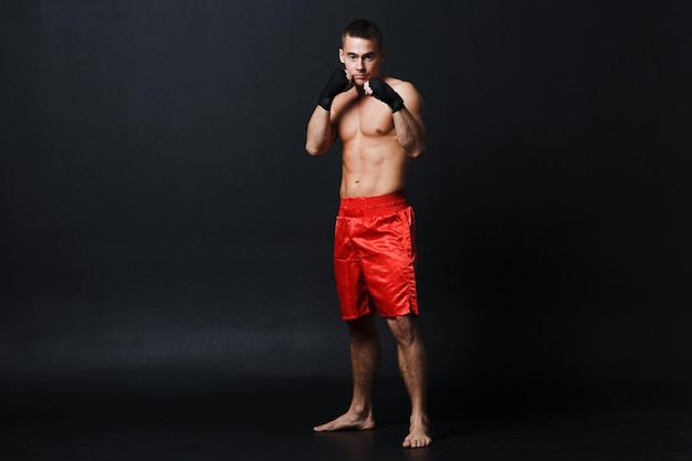 Photo portrait of young man standing against black background