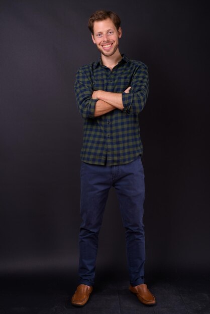 Photo portrait of young man standing against black background