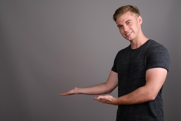 Photo portrait of young man standing against black background