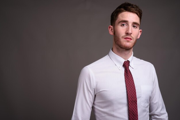 Photo portrait of young man standing against black background