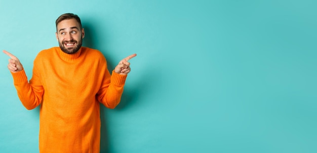 Portrait of young man standing against blue background