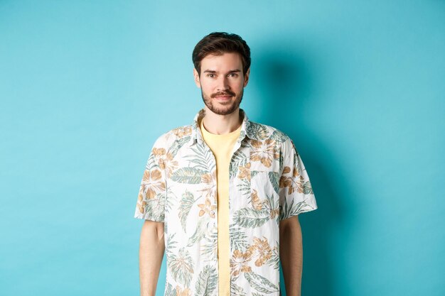 Portrait of young man standing against blue background