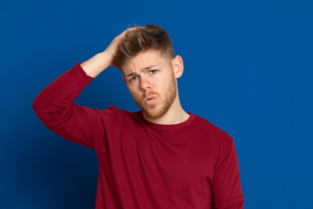 Portrait of young man standing against blue background