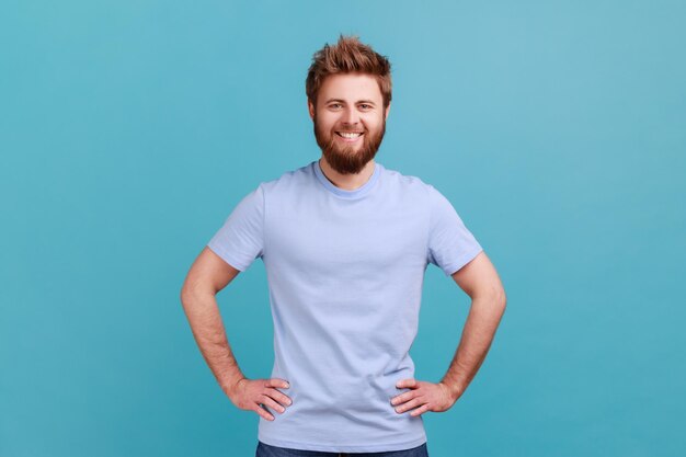 Portrait of young man standing against blue background