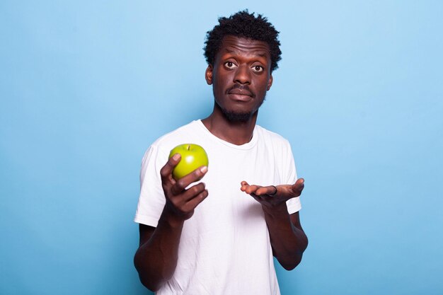 Portrait of young man standing against blue background