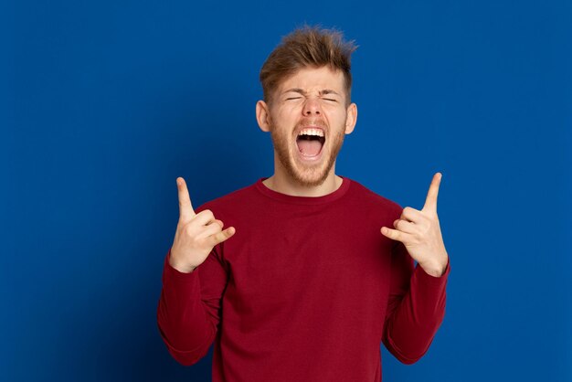 Portrait of young man standing against blue background