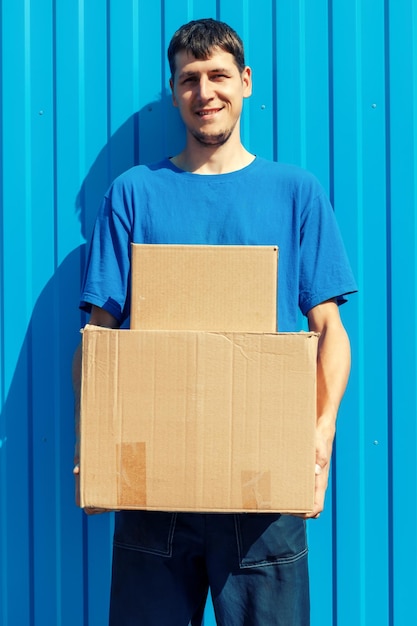 Photo portrait of young man standing against blue wall