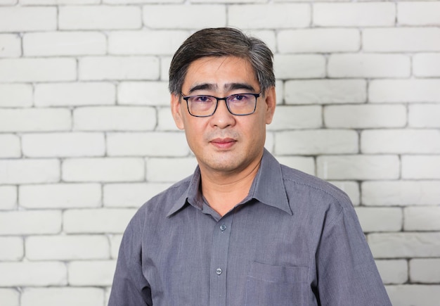 portrait of young man standing against brick wall