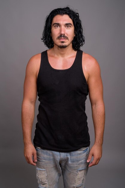 Photo portrait of young man standing against gray background