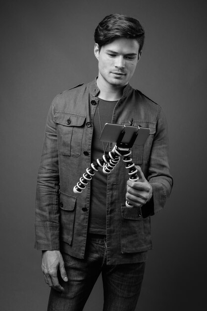 Photo portrait of young man standing against gray background