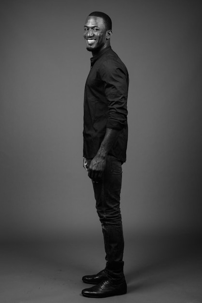 Photo portrait of young man standing against gray background