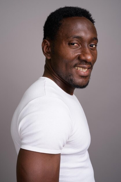 Portrait of young man standing against gray background