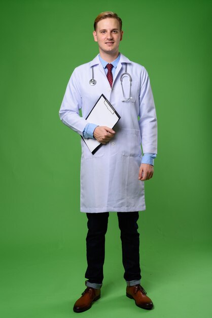 Portrait of young man standing against gray background