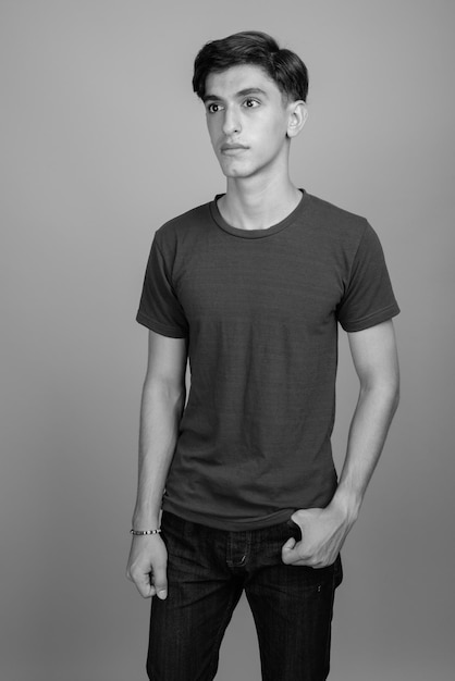 Photo portrait of young man standing against gray background