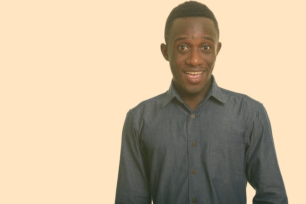 Portrait of young man standing against gray background