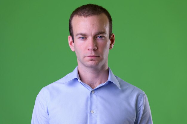 Photo portrait of young man standing against green background