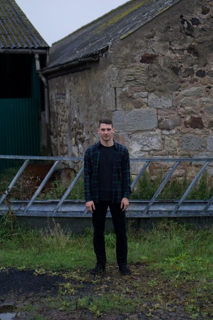 Photo portrait of young man standing against houses