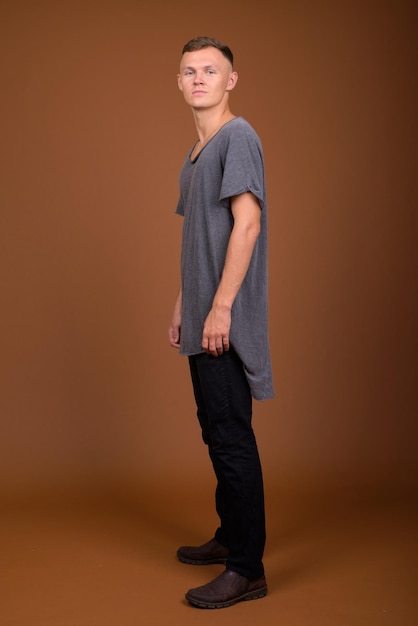 Photo portrait of young man standing against orange background