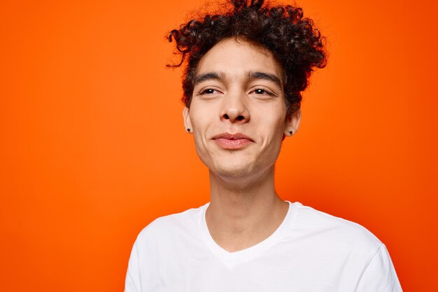 Portrait of young man standing against orange background