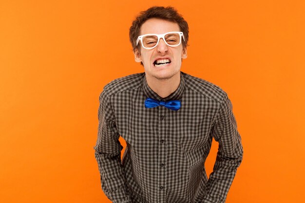 Portrait of young man standing against orange background