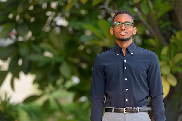 Portrait of young man standing against plants