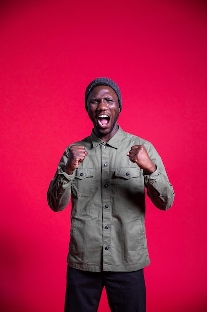 Photo portrait of young man standing against red background