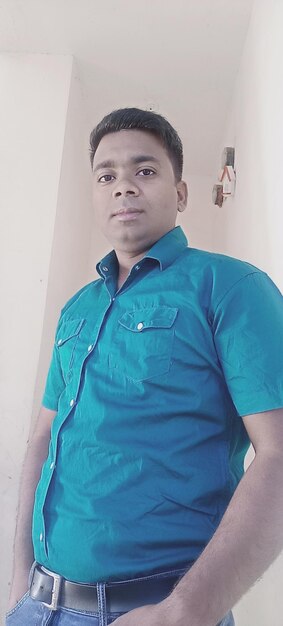 Portrait of young man standing against wall