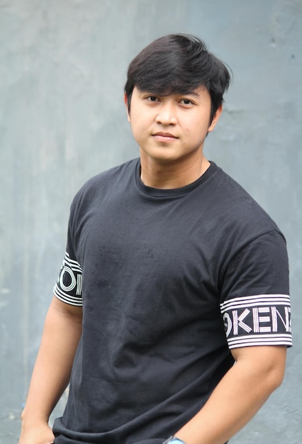 Photo portrait of young man standing against wall