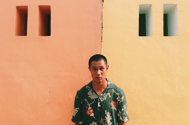 portrait of young man standing against wall