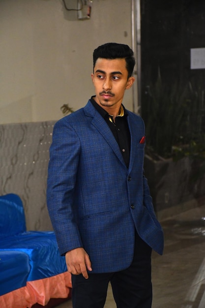 Portrait of young man standing against wall