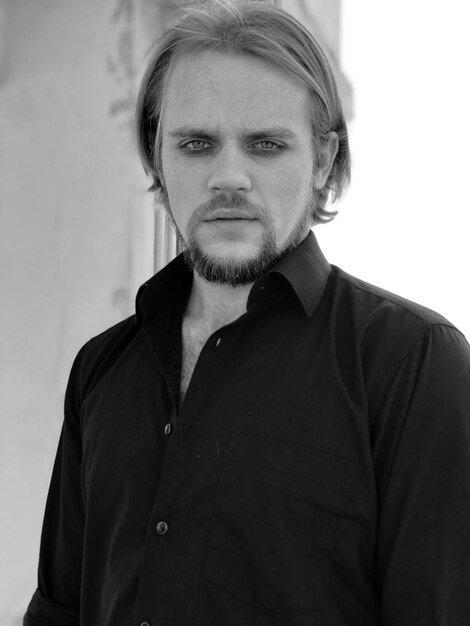 Photo portrait of young man standing against wall