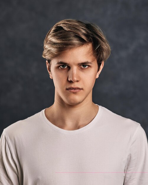 Photo portrait of young man standing against wall