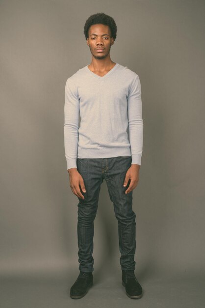 Portrait of young man standing against wall