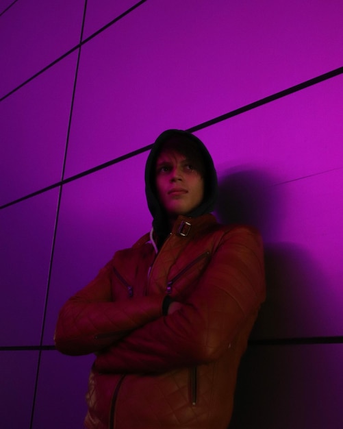 Portrait of young man standing against wall