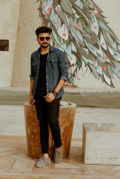 Photo portrait of young man standing against wall