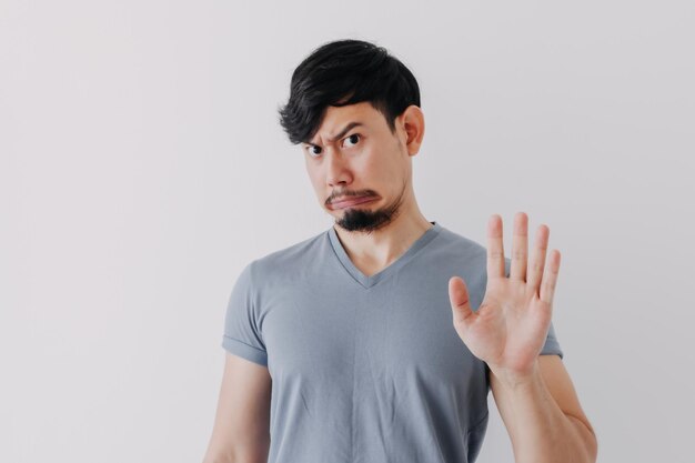 Portrait of young man standing against white background