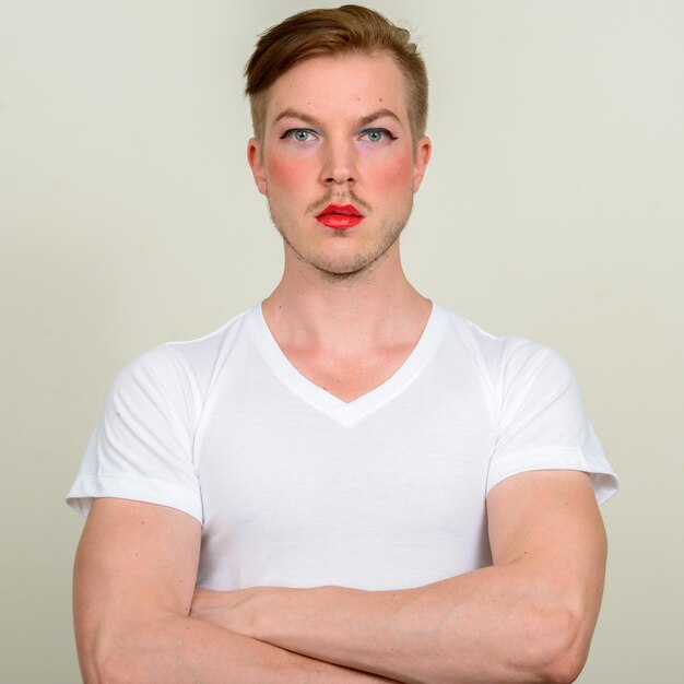 Portrait of young man standing against white background